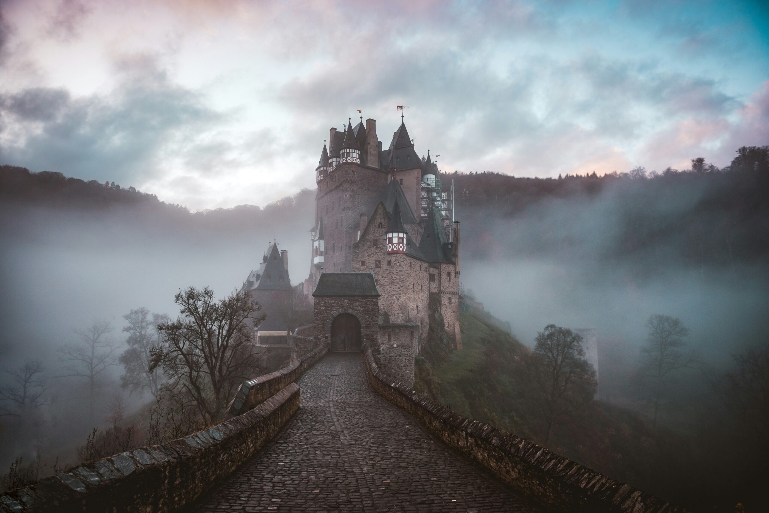 A photo of a small castle surrounded by a light mist.